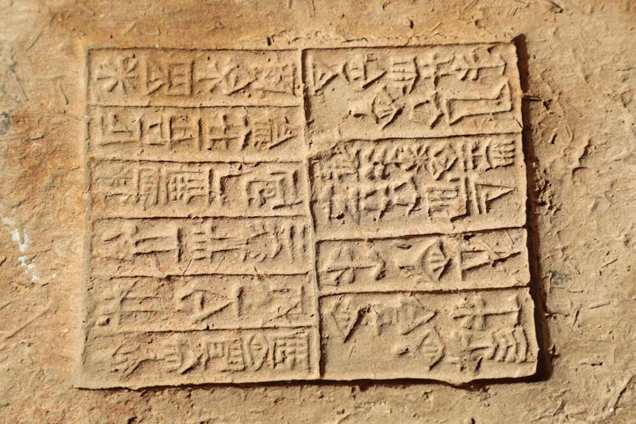 caption: Cuneiform inscription is seen during excavation at the ancient Sumerian city of Girsu, now known as Tello, in Iraq's al-Shatrah district of the southern Dhi Qar province on November 14, 2021. (Asaad Niazi/AFP via Getty Images)