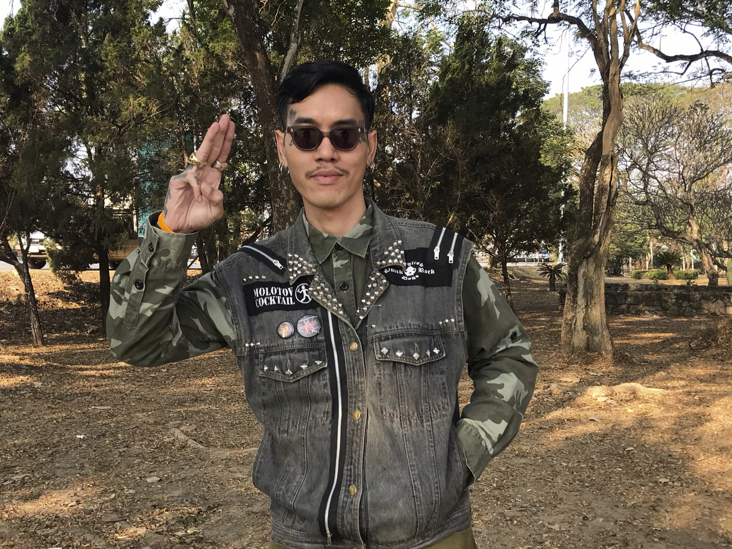 caption: Political activist Mongkhon Thirakot flashes the pro-democracy gesture of a three-finger salute ahead of going to a court in Thailand's northern province of Chiang Rai, Thailand, Thursday Jan. 26, 2023.