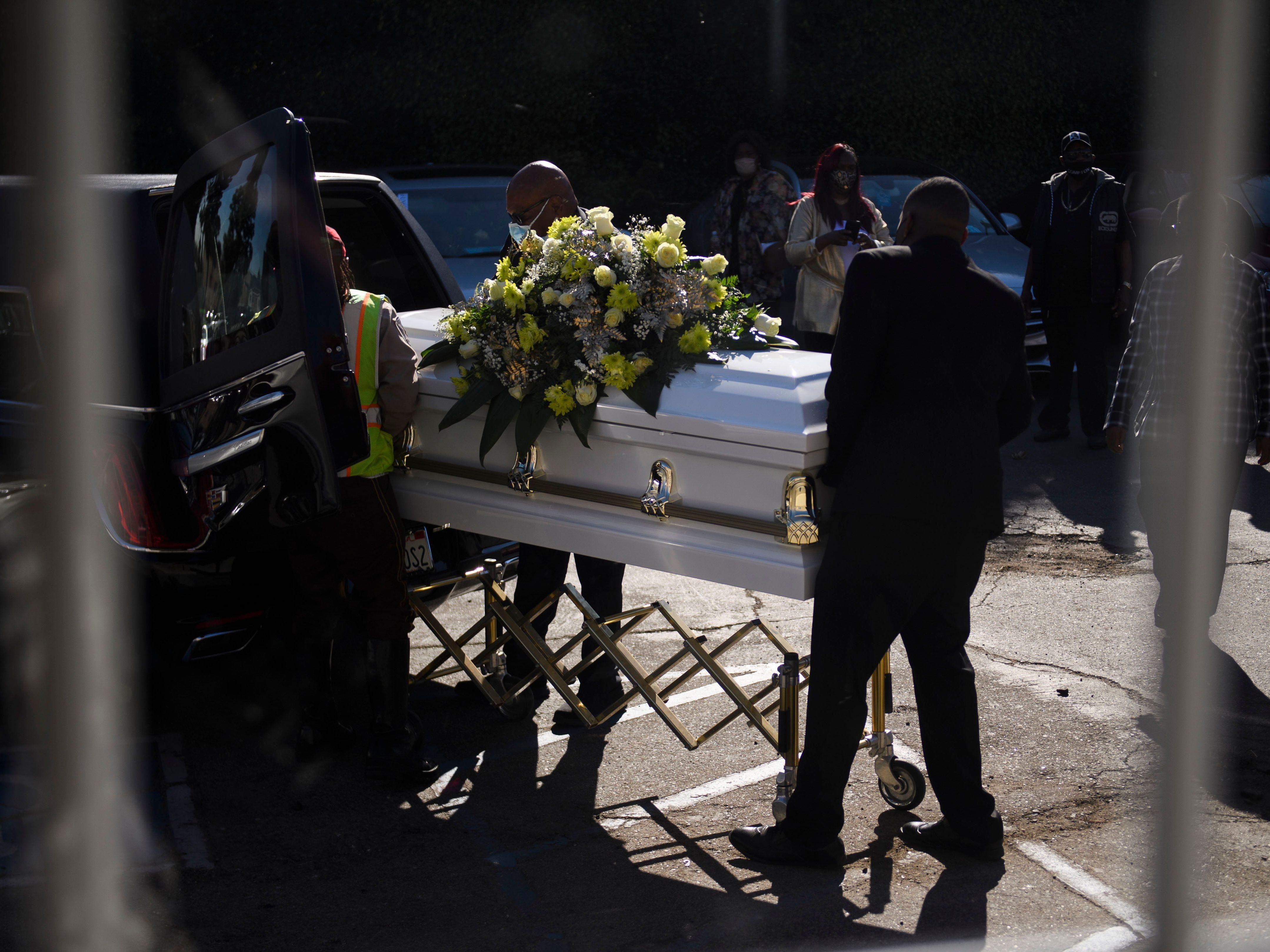 caption: A casket is loaded into a hearse at the Boyd Funeral Home as burials at cemeteries are delayed to the surge of COVID-19 deaths on Jan. 14, 2021 in Los Angeles.