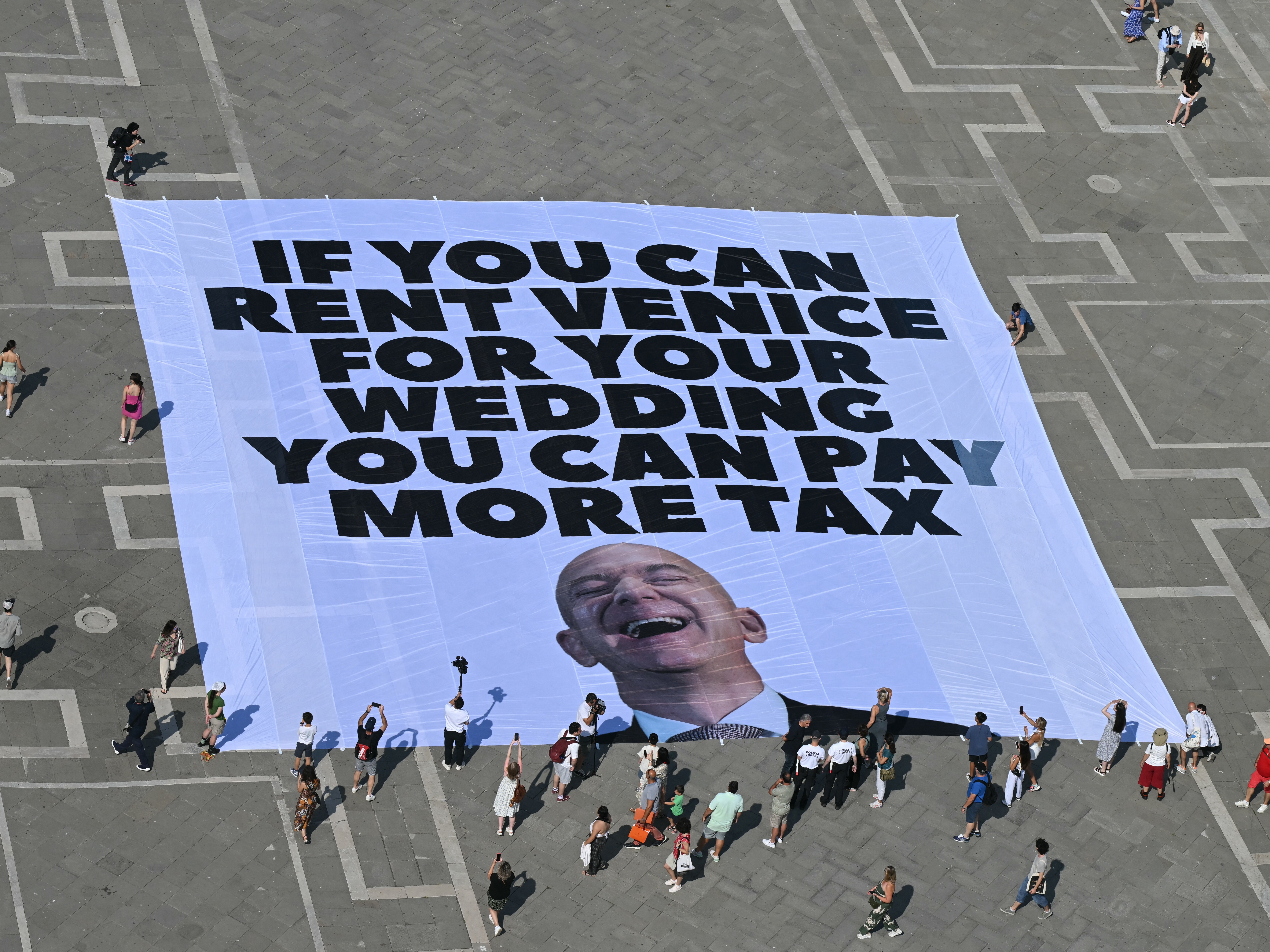 caption: Activists with the international environmental group Greenpeace display a giant banner displaying a picture of Jeff Bezos in Venice's St. Mark's Square on Monday.