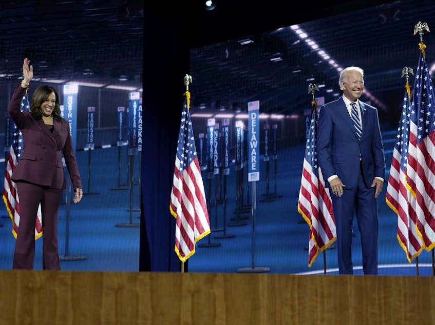caption: Sen. Kamala Harris stands on stage with former Vice President Joe Biden after she spoke during the Democratic National Convention.