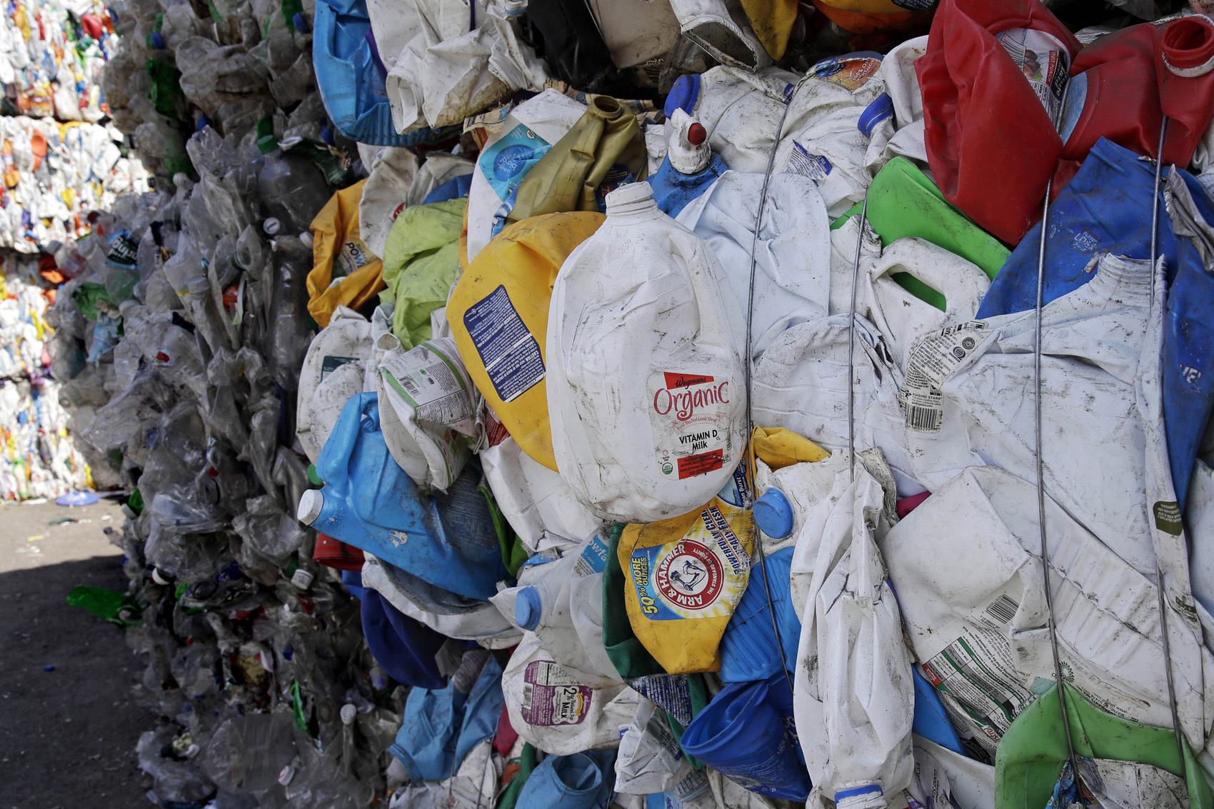 caption: Bundled plastic goods, which were separated from paper and metal recyclable materials, are stacked and awaiting processing at EL Harvey & Sons, a waste and recycling company, in Westborough, Mass. (Charles Krupa/AP)