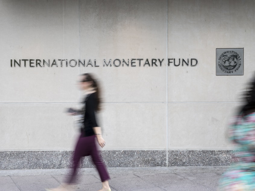 Pedestrians walk past the International Monetary Fund (IMF) headquarters in Washington, D.C.