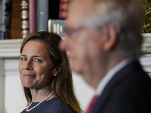 caption: Supreme Court nominee Judge Amy Coney Barrett looks over to Senate Majority Leader Mitch McConnell of Kentucky on Capitol Hill Tuesday.