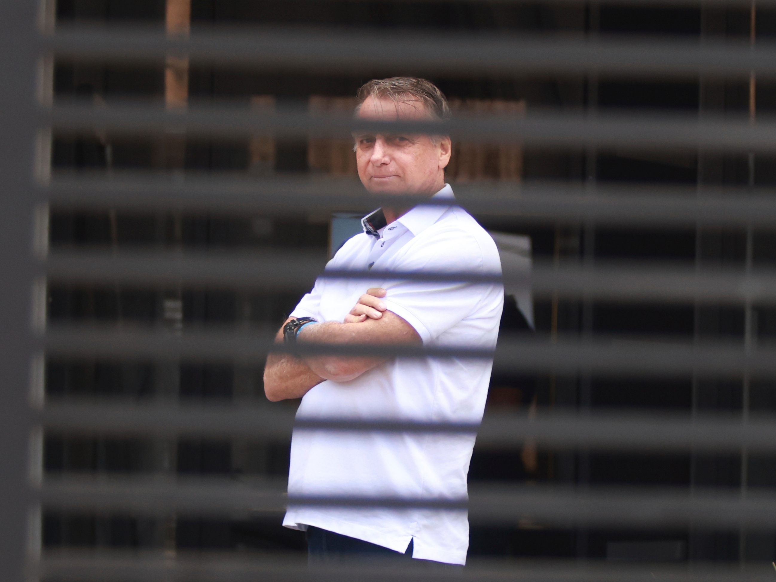 caption: Brazil's former President Jair Bolsonaro stands at the entrance of his home where he was under house arrest in Brasilia, Brazil, on Sept. 2.