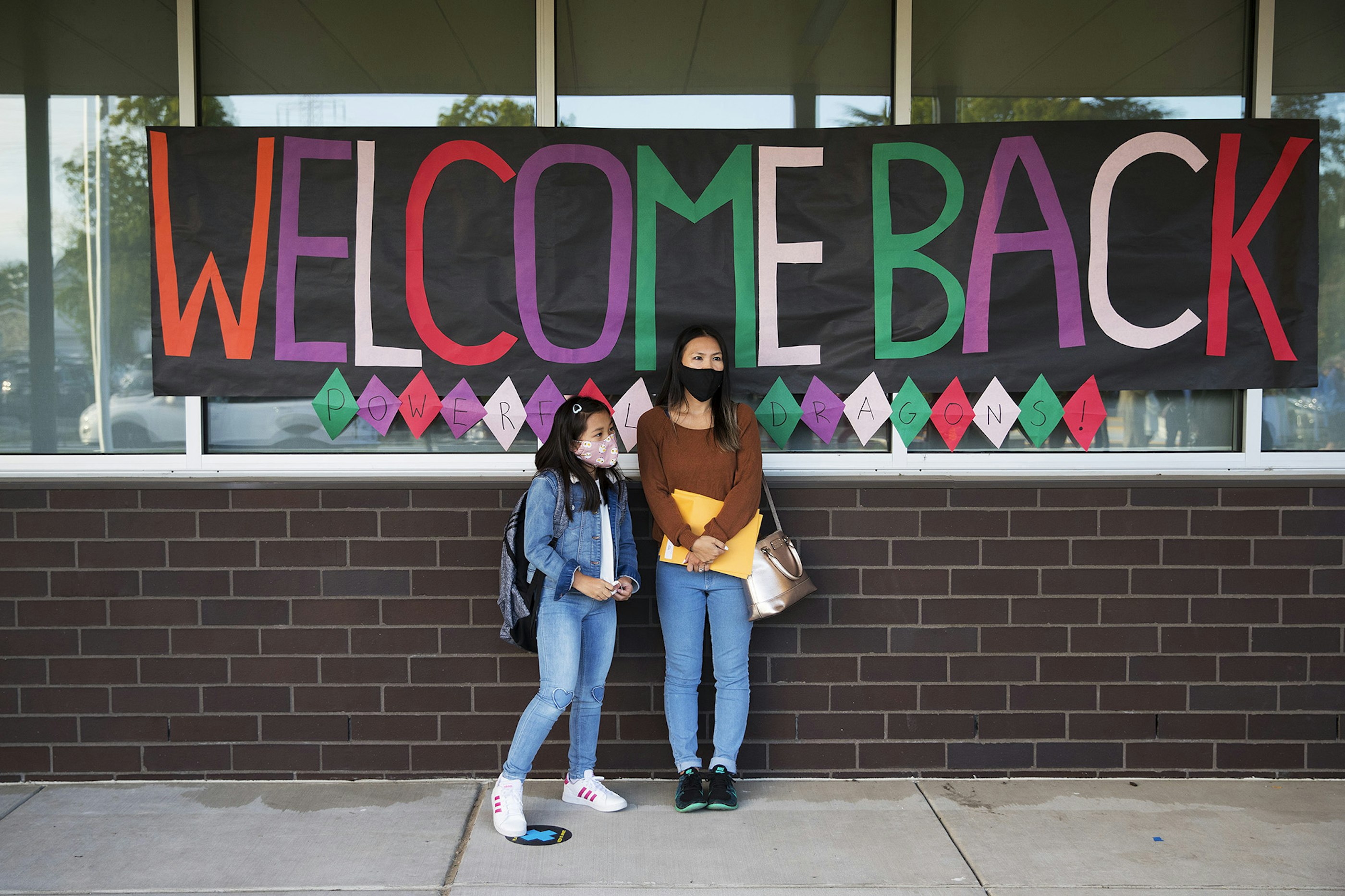 Third-grade student Maliyah Ouk, 8, stands with her mother Victoria Saetern before the first day of school begins at Wing Luke Elementary School on Wednesday, September 1, 2021, along Kenyon Street in Seattle.