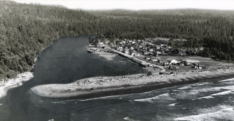 caption: Undated aerial photo, circa 1930, shows Taholah, Washington, and the mouth of the Quinault River.