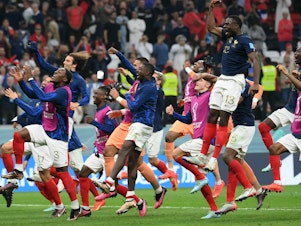 caption: France's players celebrate their victory in a 2022 World Cup semifinal match with Morocco on Wednesday, Dec. 14, at the Al-Bayt Stadium in Al Khor, north of Doha.