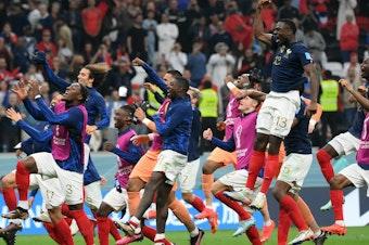 caption: France's players celebrate their victory in a 2022 World Cup semifinal match with Morocco on Wednesday, Dec. 14, at the Al-Bayt Stadium in Al Khor, north of Doha.