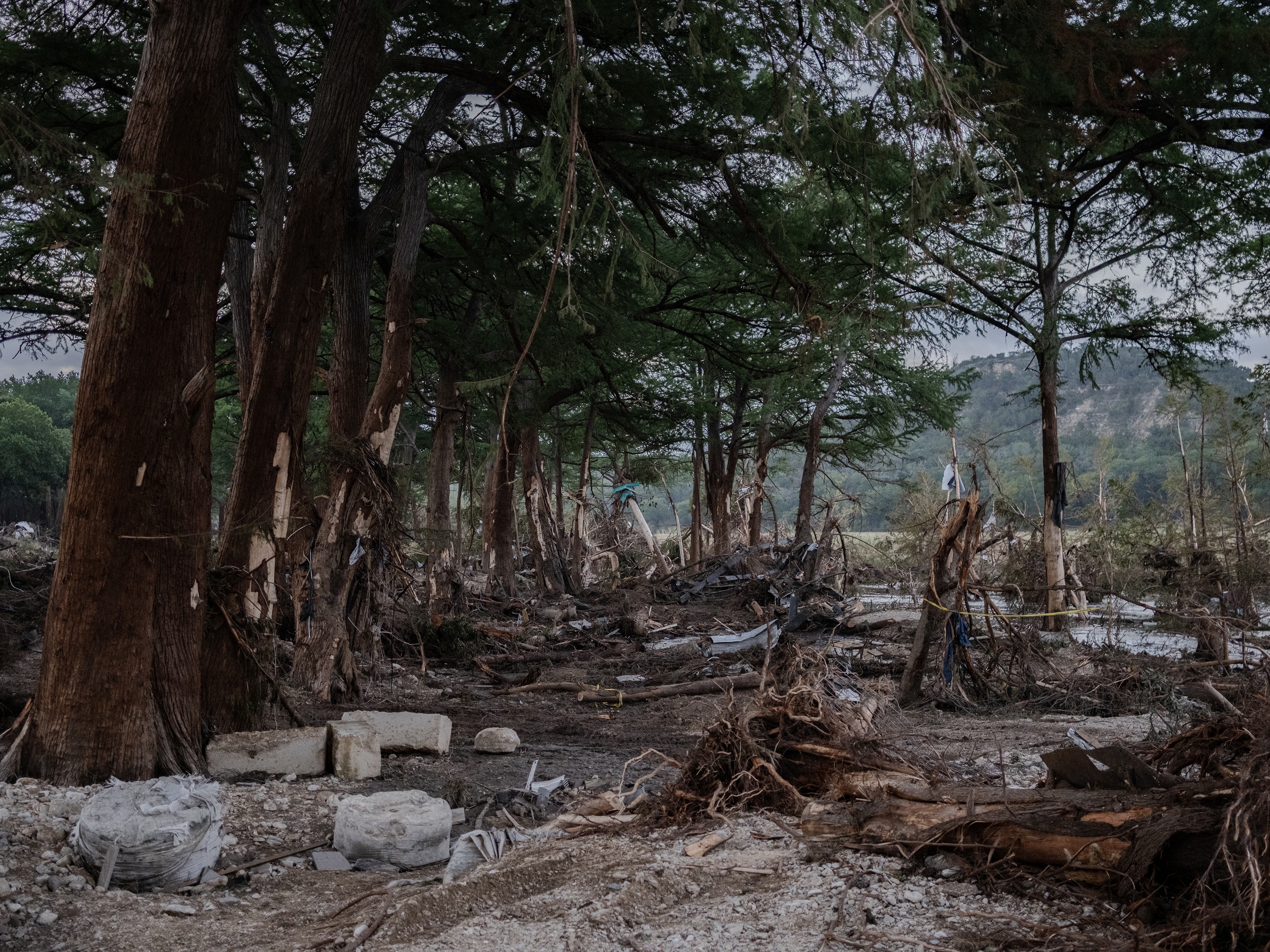 caption: Debris lies along the Guadalupe River on Tuesday after it was swept up in the flash flooding in Ingram, Texas. More than 100 fatalities were reported after heavy rainfall caused flooding along the river in central Texas.
