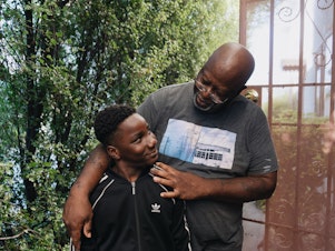 caption: Ziare Gearring (left) and his grandfather Ricky Brown pose for a portrait outside of their home in Los Angeles. The 65-year-old retired handyman had already been struggling, and taking in three grandsons after his ex-wife's sudden death has put him thousands of dollars behind on rent and utilities.