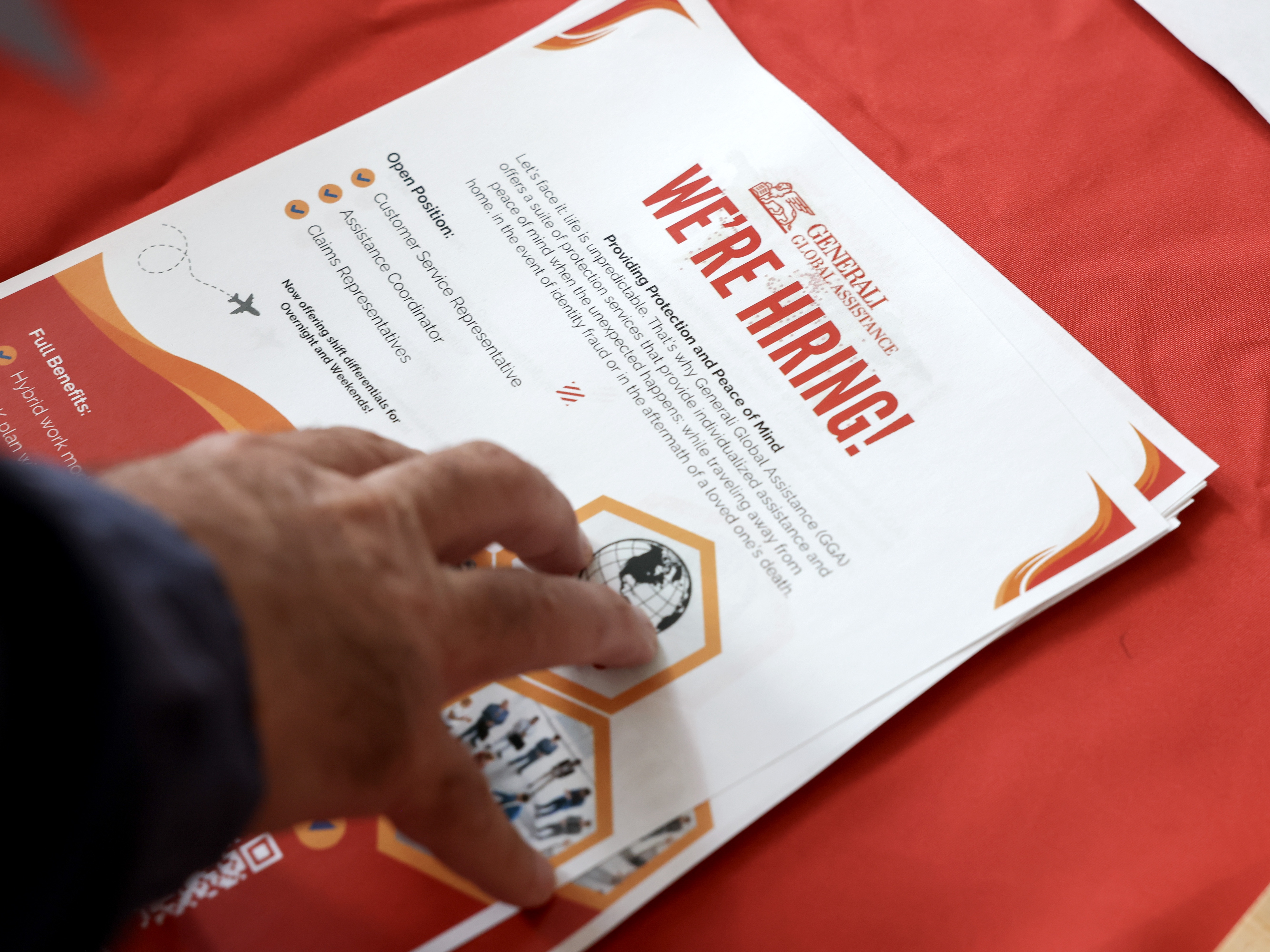 caption: A 'we're hiring' pamphlet at the Mega JobNewsUSA South Florida Job Fair at the Amerant Bank Arena in Sunrise, Fl., on April 30, 2025. Employers continued to add jobs in April, even as Trump's trade war took a toll on economic growth.