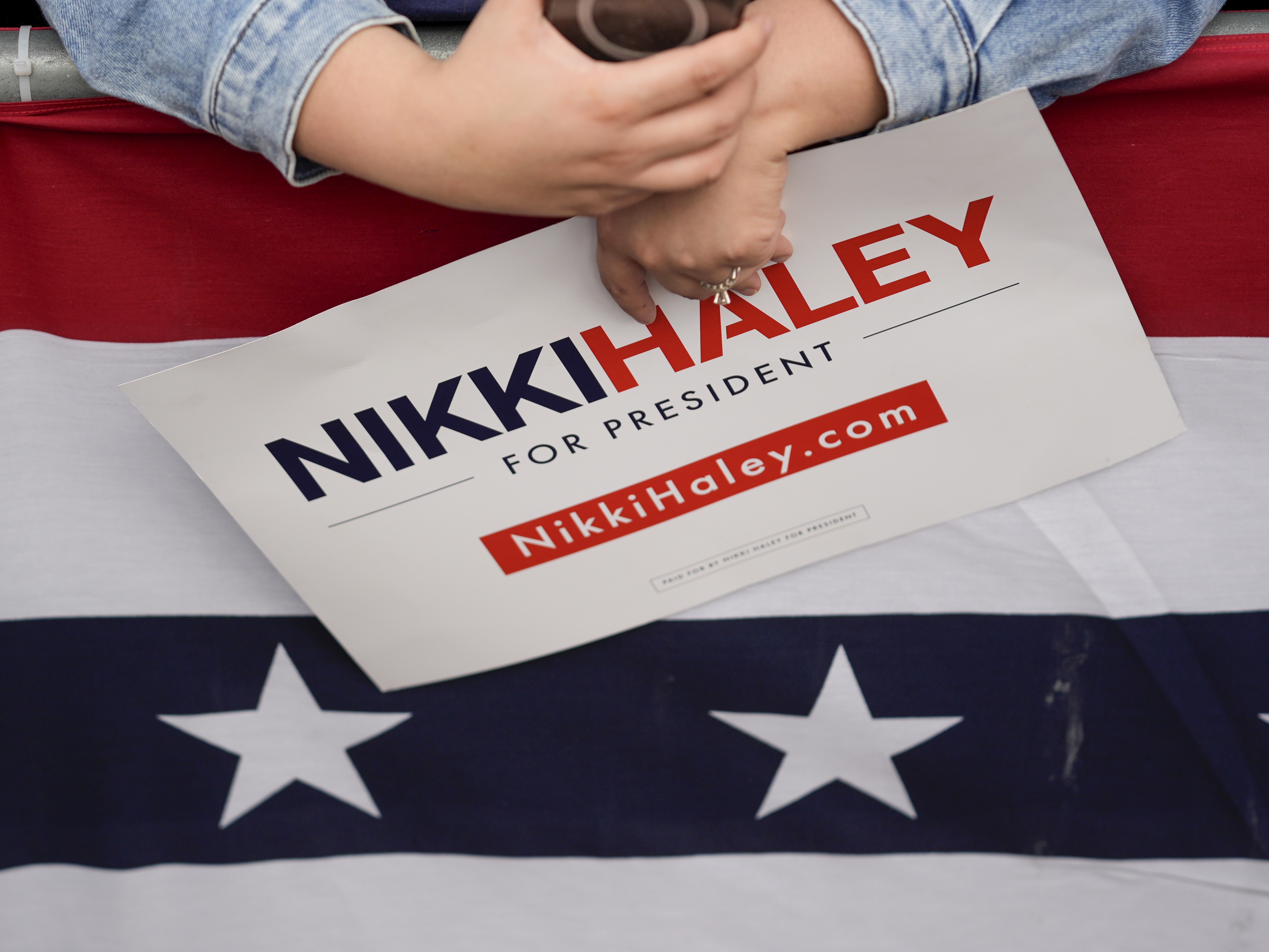 caption: A supporter holds a sign during a rally for former Republican presidential candidate and former U.N. Ambassador Nikki Haley on Feb. 16 in San Antonio.
