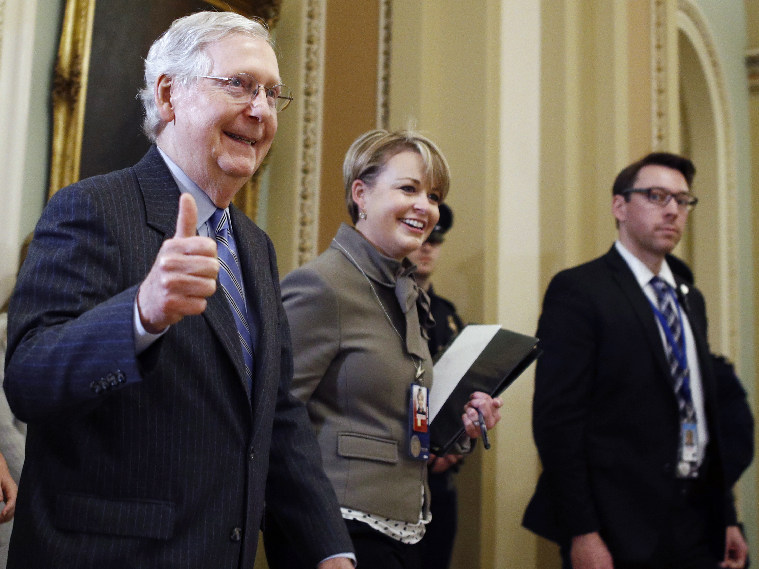 caption: Senate Majority Leader Mitch McConnell, R-Ky., gives a thumbs up as he leaves the Senate chamber during the impeachment trial of President Trump on Friday.