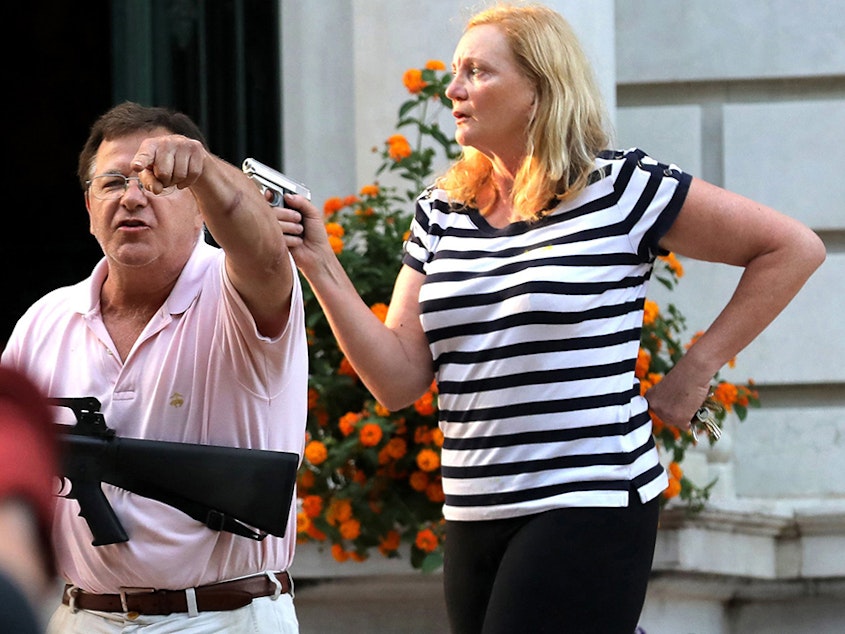 caption: Armed homeowners Mark and Patricia McCloskey confront protesters marching to St. Louis Mayor Lyda Krewson's house on June 28. The St. Louis Metropolitan Police has issued citations for trespassing to nine protesters, and these are under review by the city counselor's office.