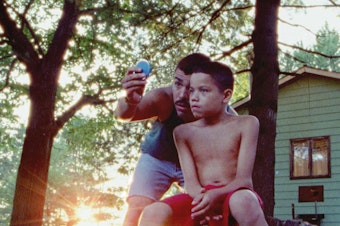 caption: Jonah (Evan Rosado) is the youngest of three children who roam under the auspices of their father (Raul Castillo) in the film adaptation of <em>We the Animals.</em>