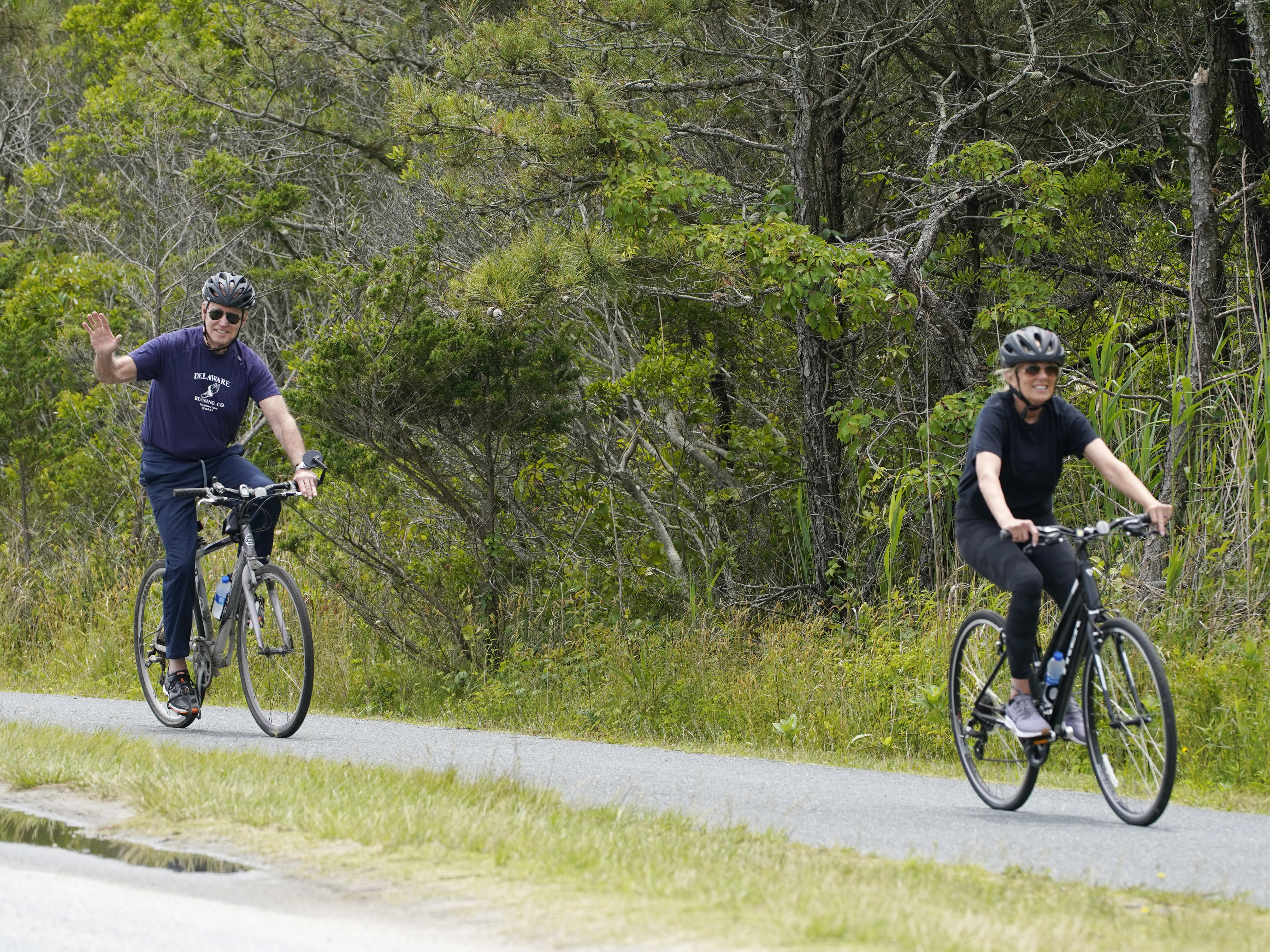 caption: President Biden rides his bike in Rehoboth Beach, Del., earlier this year with first lady Jill Biden. The family has a beach house nearby.