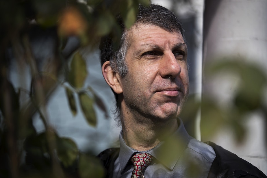 caption: Joe Dibee is portrayed while sitting on the porch of his family's home on Wednesday, February 17, 2021, in Seattle. 