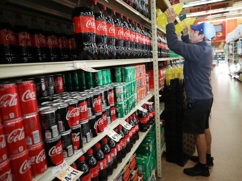 caption: A worker restocks sodas at a Hispanic specialty supermarket in Los Angeles on March 19. Nationally, sales of soft drinks were up 43% that week, compared to the same week in 2019.