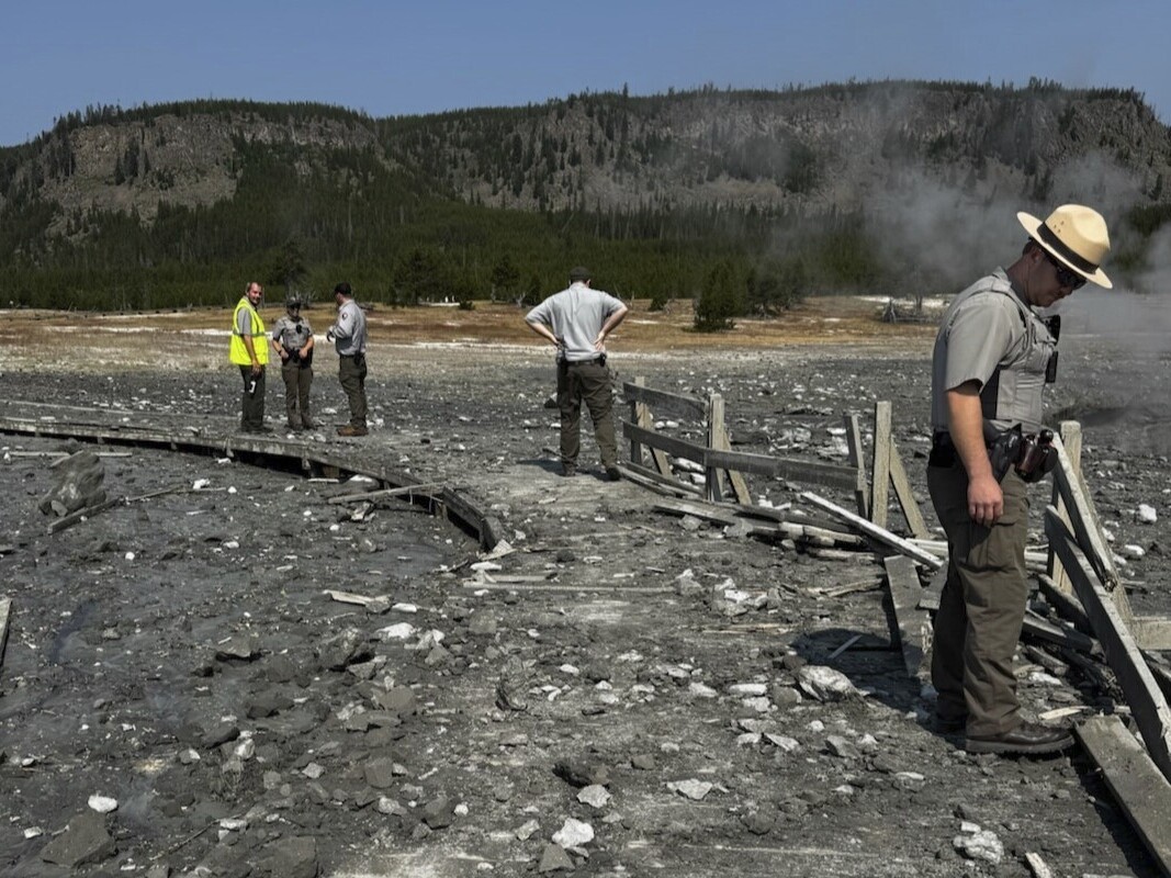 caption: In this photo released by the National Park Service, park staff assess the damage to Biscuit Basin boardwalks after a hydrothermal explosion at Biscuit Basin in Yellowstone National Park, Wyo., on Tuesday.