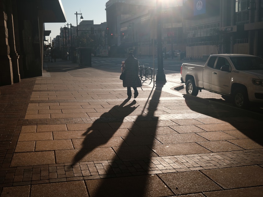 caption: A person walks down a street in Philadelphia, Pa.