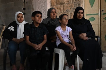 caption: The family of Bilal Muhammed Saleh outside their home in  As-Sawiya, occupied West Bank on Oct. 31, 2023.