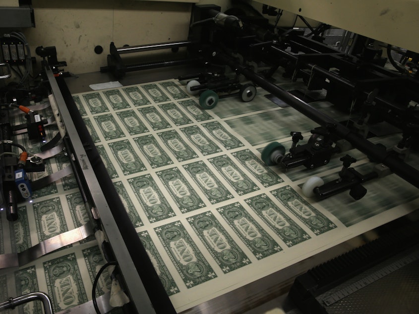 caption: Sheets of $1 bills run through the printing press in 2015 at the U.S. Bureau of Engraving and Printing in Washington, D.C. National debt is expected to reach an all-time high of 107% of gross domestic product in 2023.