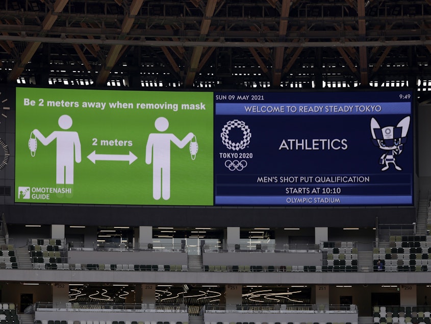 caption: Signs on a screen are shown before an athletics test event for the Tokyo 2020 Olympic Games last month at the National Stadium in Tokyo.