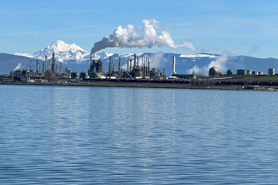 caption: Mount Baker looms behind the Marathon Petroleum refinery on Fidalgo Bay in Anacortes, Washington, on Mar. 16, 2024.