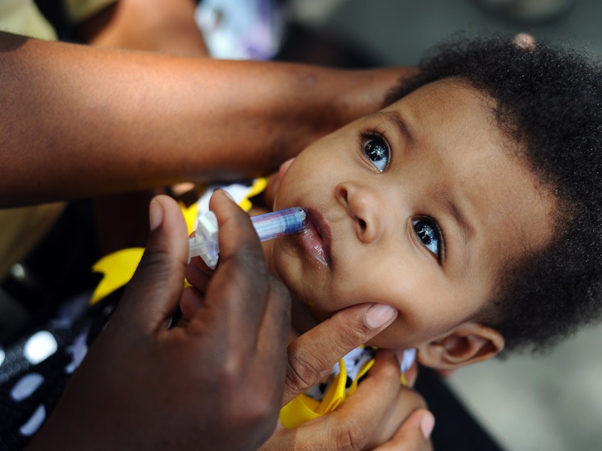 caption: A nurse administers the rotavirus vaccine, given during the first year of a baby's life.