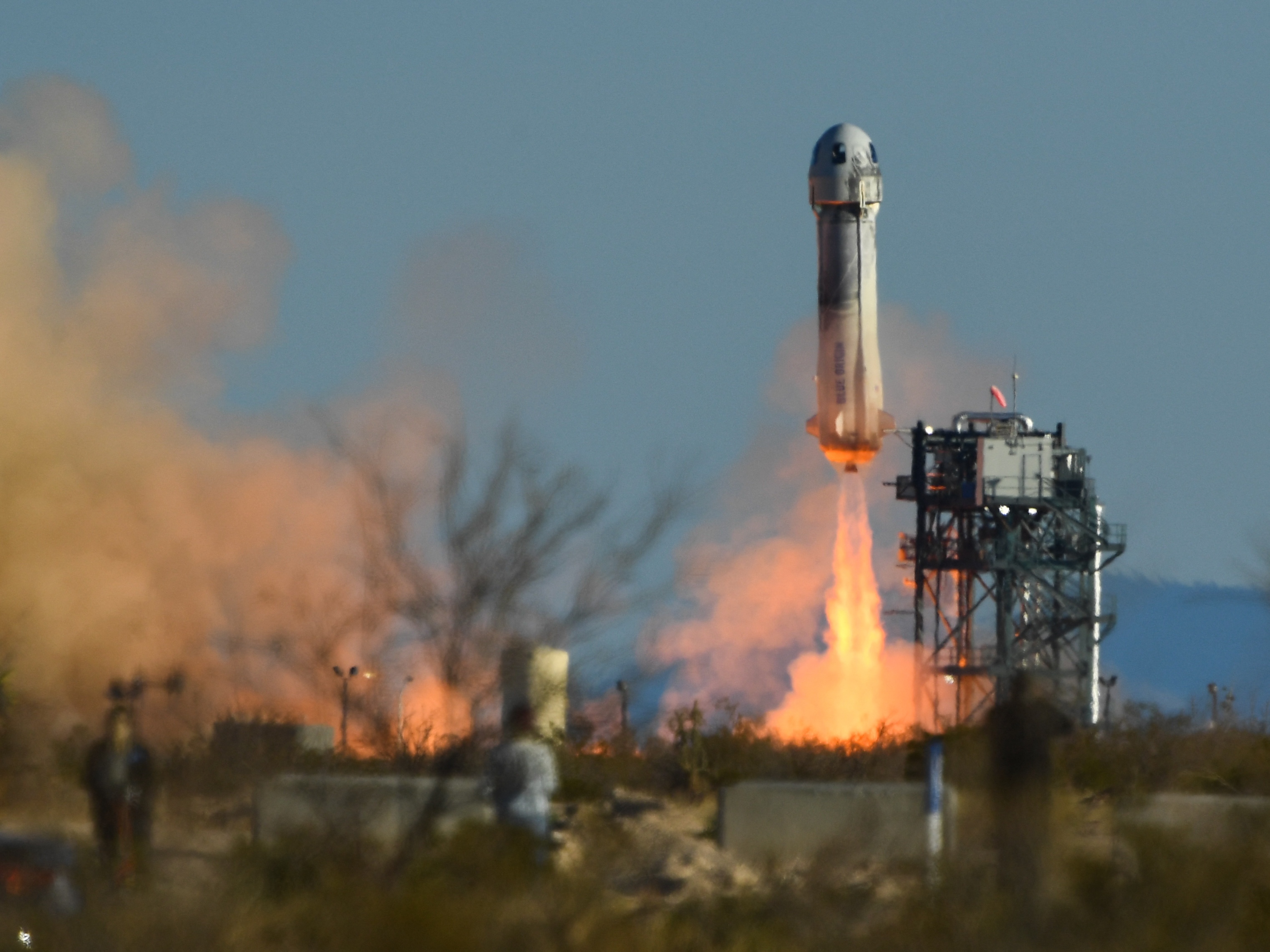 caption: A Blue Origin New Shepard rocket launches from West Texas on March 31, 2022. Blue Origin has announced its stopping human space launches for at least two years as it focuses on helping NASA return humans to the moon.