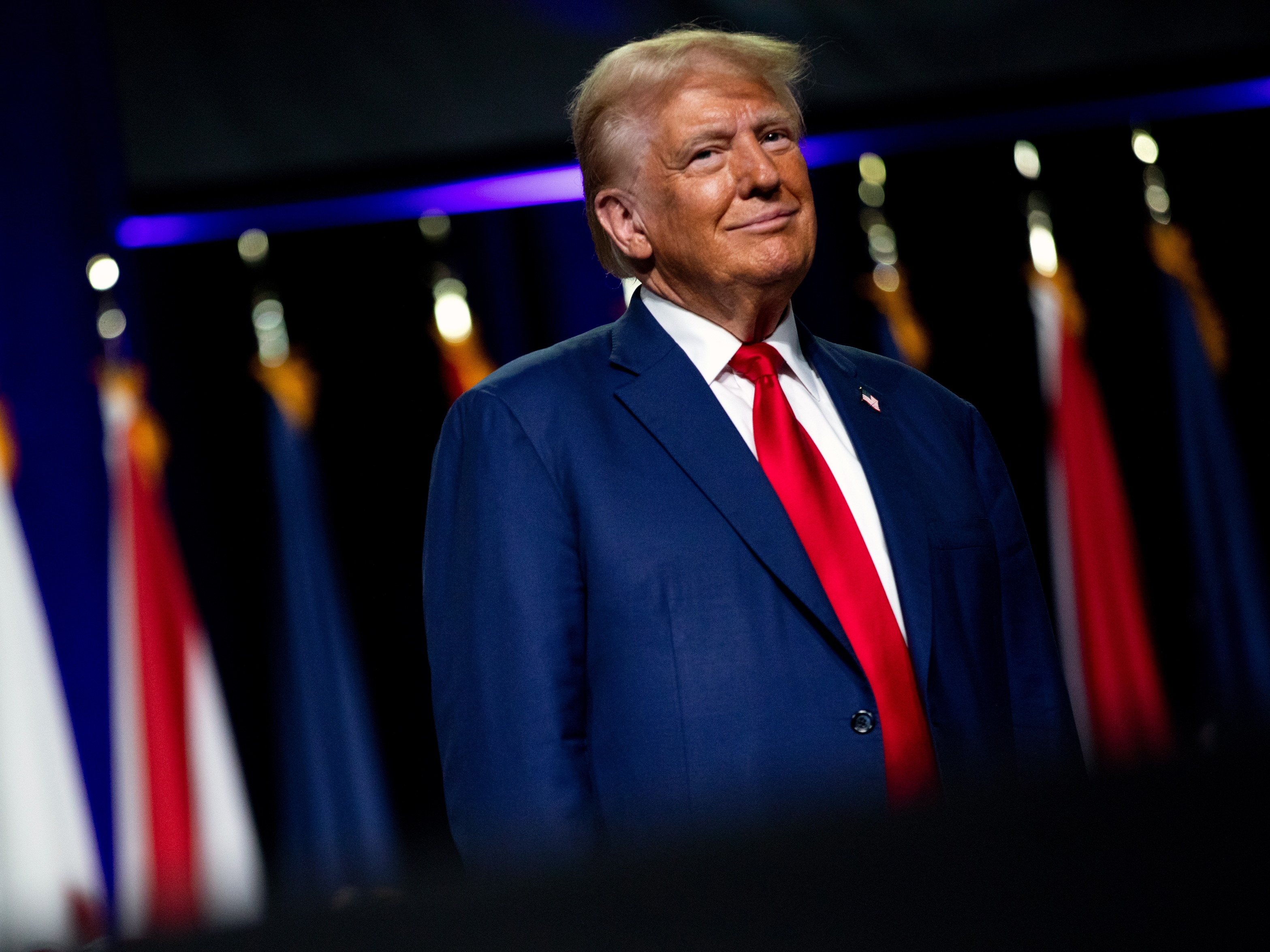 caption: Republican presidential nominee and former President Donald Trump smiles at a crowd in Detroit on Monday.