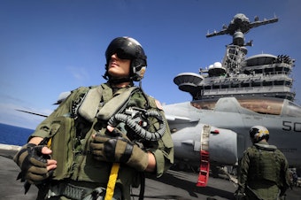caption: Lt. Roy Walker, from the Electronic Attack Squadron (VAQ) on the flight deck of the aircraft carrier USS John C. Stennis.
