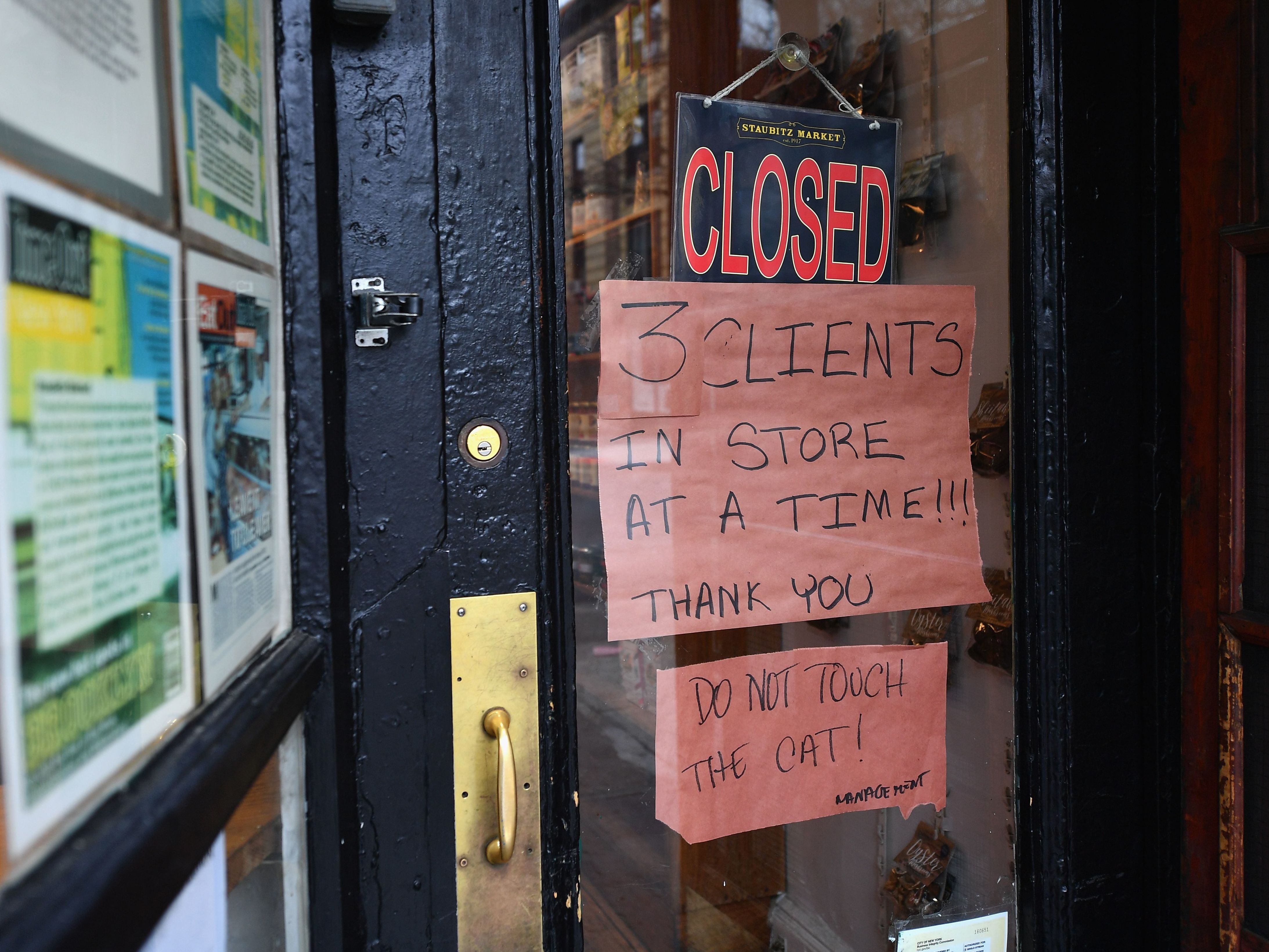 caption: A butcher shop in the Brooklyn borough of New York shows a "Closed" sign, limiting customers to three at a time. Gov. Andrew Cuomo is ordering all non-essential businesses to close, in an escalation of the state's attempts to contain the COVID-19 pandemic.