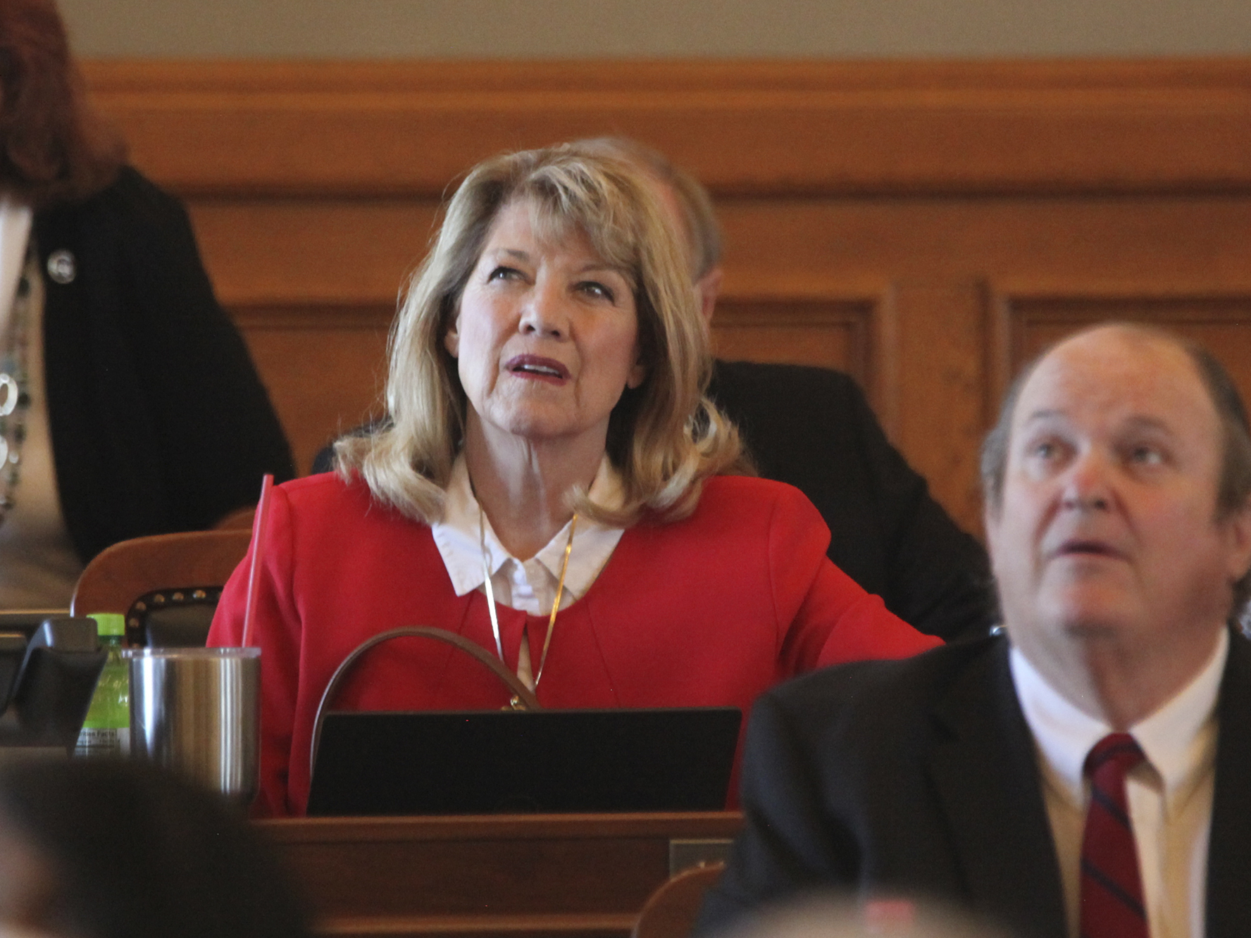 caption: Kansas state Rep. Cheryl Helmer (center), R-Mulvane, watches one of the House's electronic tally board during vote on April 26 at the Statehouse in Topeka, Kan. Helmer has complained publicly about having to share women's restrooms with a transgender colleague.