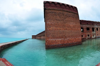 caption: Over the holiday weekend, hundreds of migrants landed in Dry Tortugas National Park, about 70 miles west of Key West, Fla., in the Gulf of Mexico. Tourists walk along the sea wall surrounding Fort Jefferson in the park in February 2016.