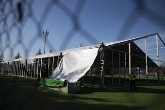 caption: A temporary 200 bed field hospital is constructed on Thursday, March 19, 2020, on a soccer field in Shoreline. 