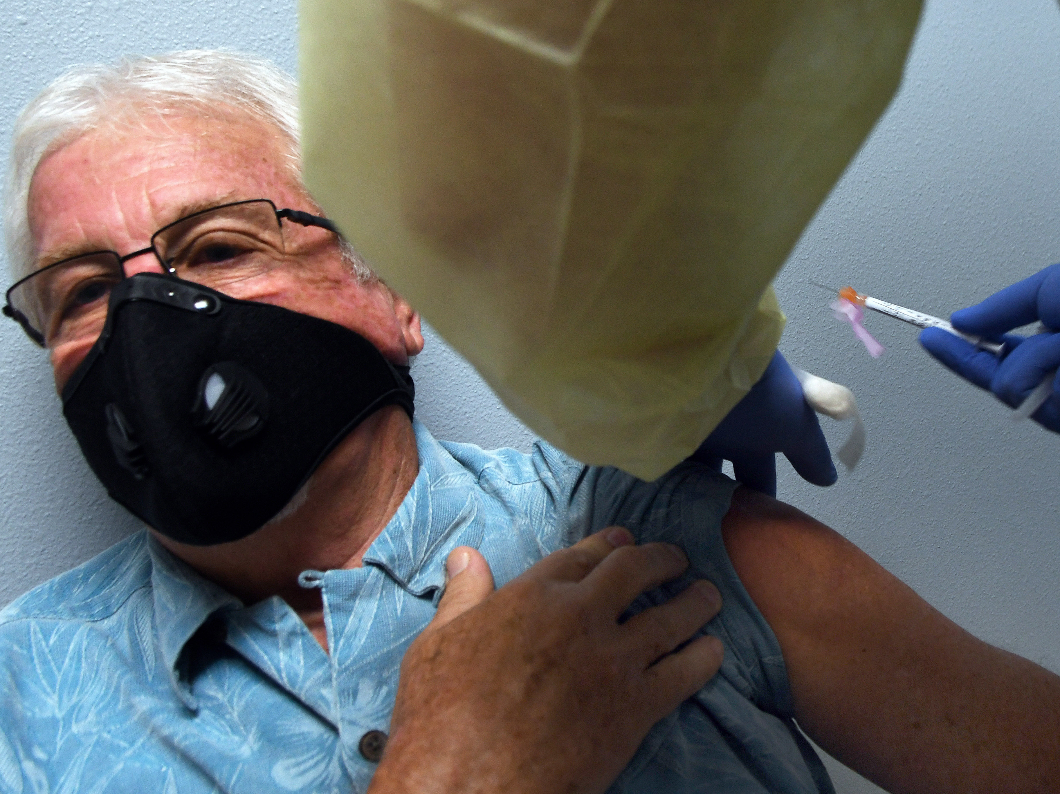 caption: Tony Potts, 69, a retiree from Ormond Beach, Fla., receives his first Moderna COVID-19 vaccine shot Tuesday as part of the company's phase three clinical trial.