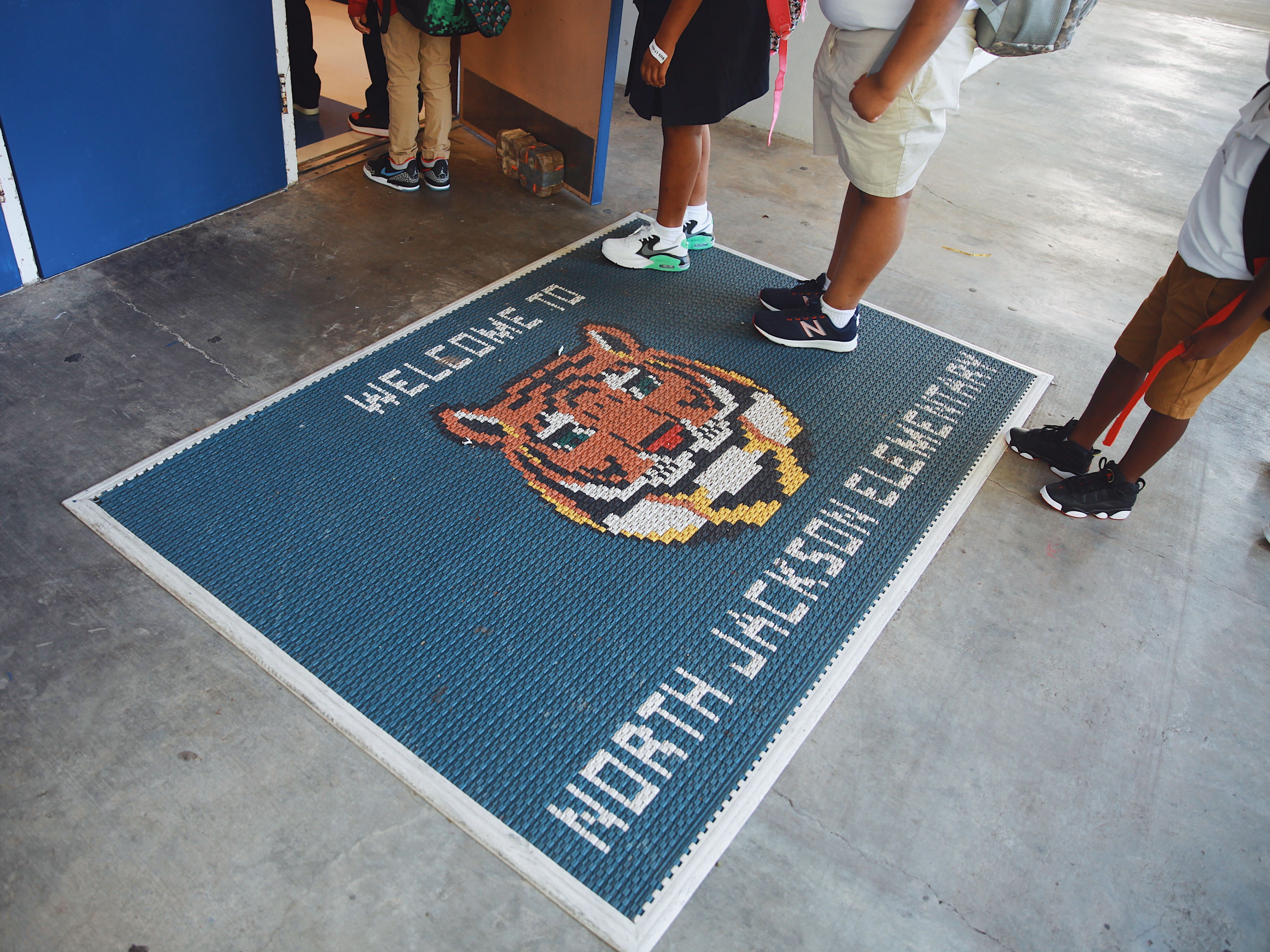 caption: Students wait in line to check in for the first day of school at North Jackson Elementary. As they walk in, they are greeted by their school mascot, the tiger.