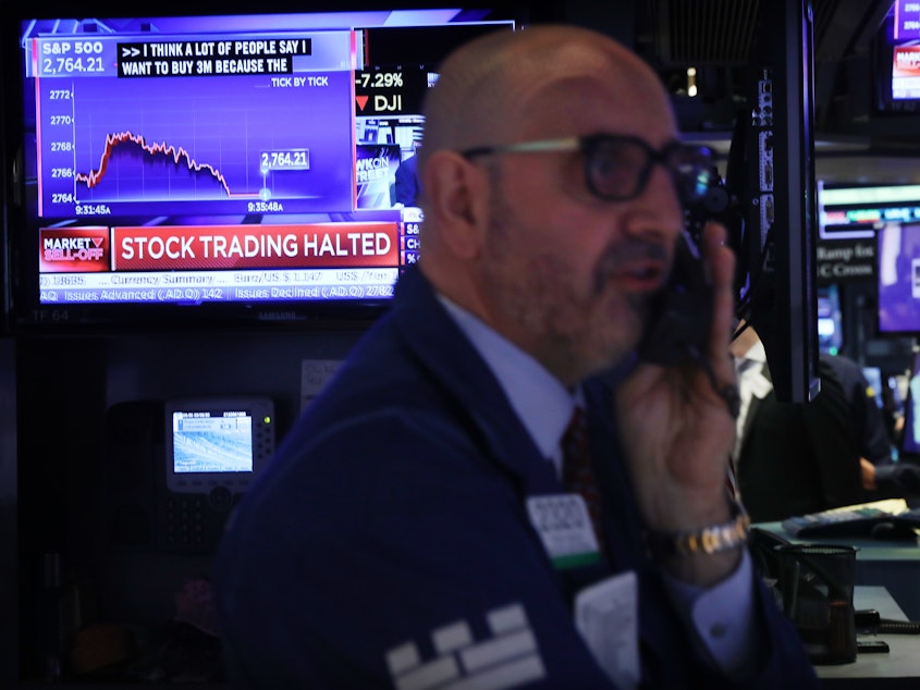 caption: Trading on the New York Stock Exchange was halted briefly Monday morning when the S&P 500 index fell 7%, triggering automatic circuit breakers.