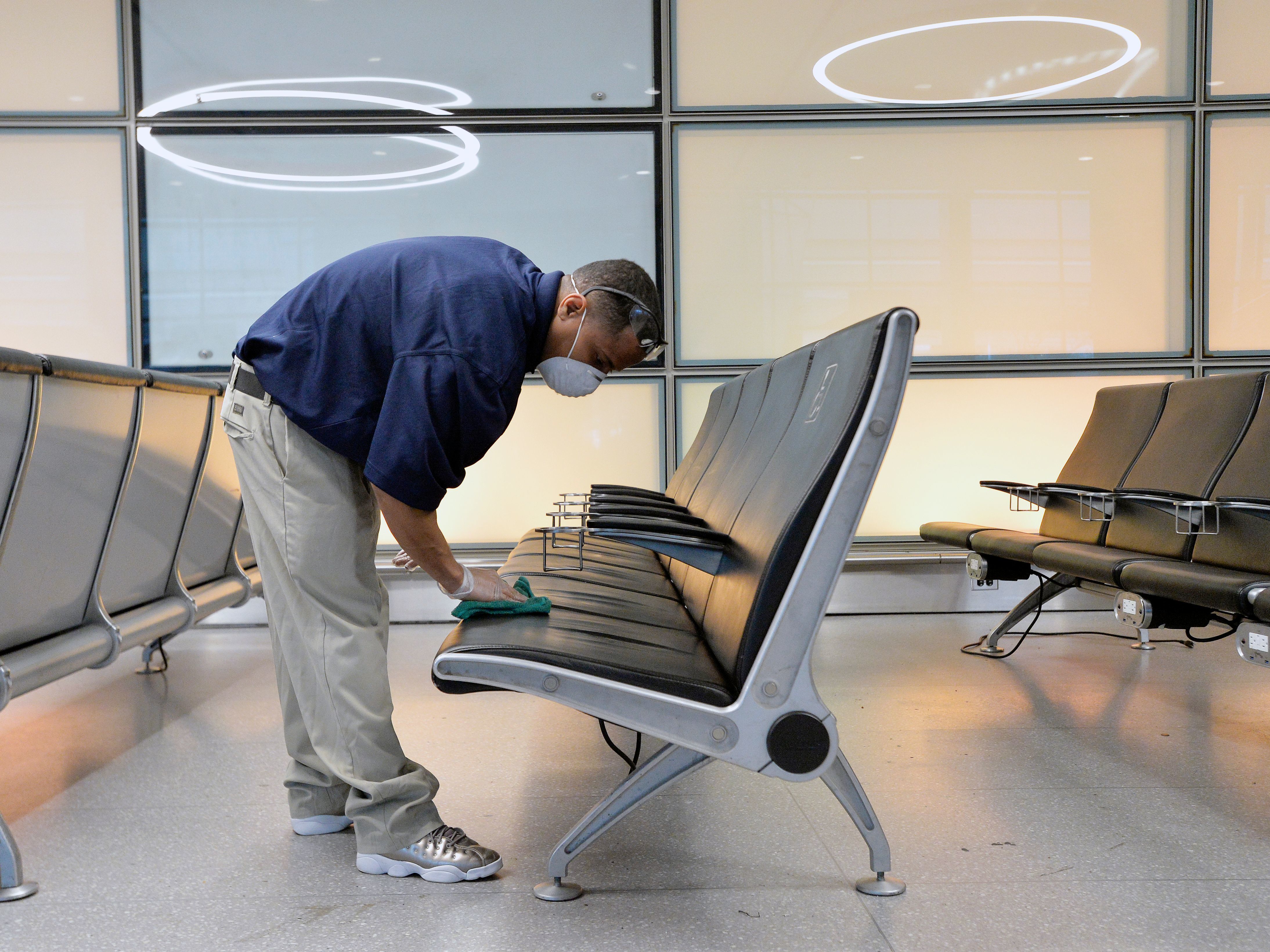 caption: An employee cleans seats Friday at Logan Airport in Boston. On Friday, the Pentagon ordered most of its military and civilian personnel to halt domestic travel in the U.S. beginning Monday, in an effort to slow down the spread of the novel coronavirus.