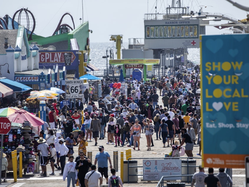 caption: The Santa Monica Pier welcomed outdoor visitors on Monday as Los Angeles County entered the less restrictive orange tier. The following day, California Gov. Gavin Newsom announced a target statewide reopening date of June 15, provided certain public health criteria are met.