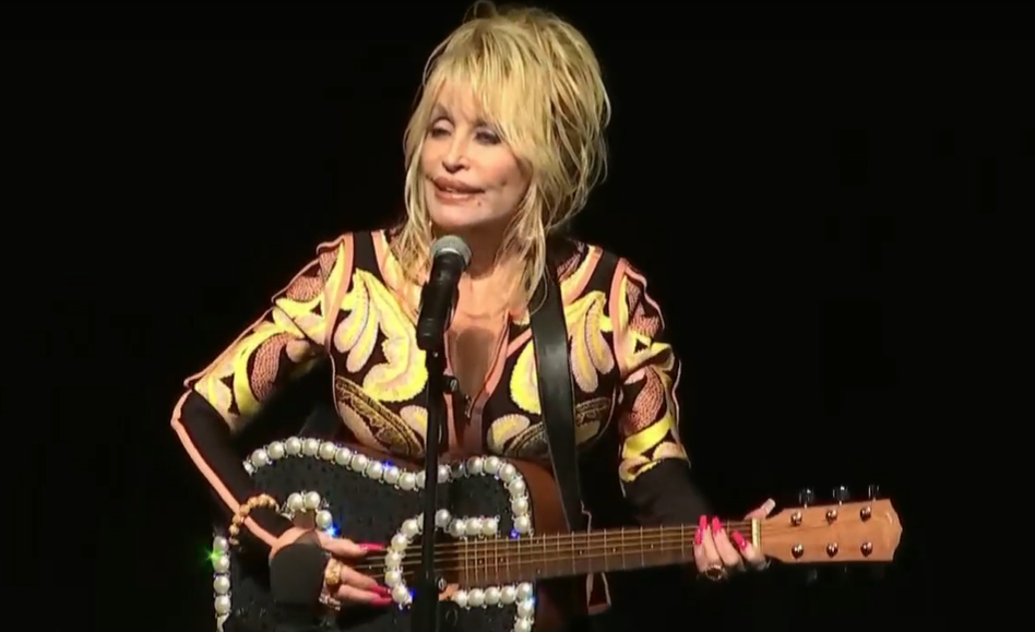 caption: Dolly Parton performs "Coat of Many Colors" at Tacoma's Pantages Theater, Aug. 15, 2023. Parton was in Washington to celebrate her "Imagination Library" going statewide. The program provides free books to children up to the age of 5. 