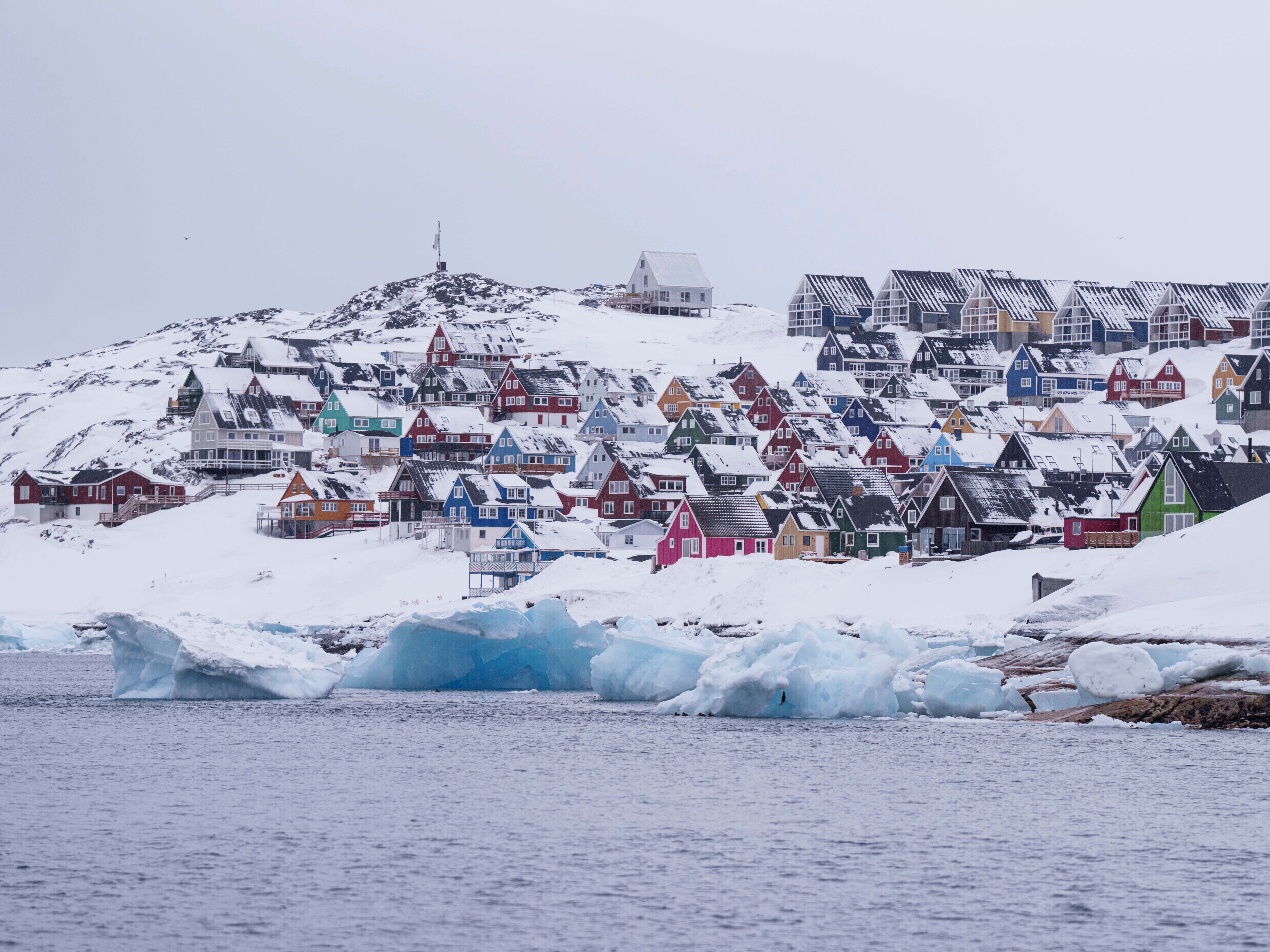 caption: Homes covered by snow are seen from the sea in Nuuk, Greenland, on March 6, 2025.