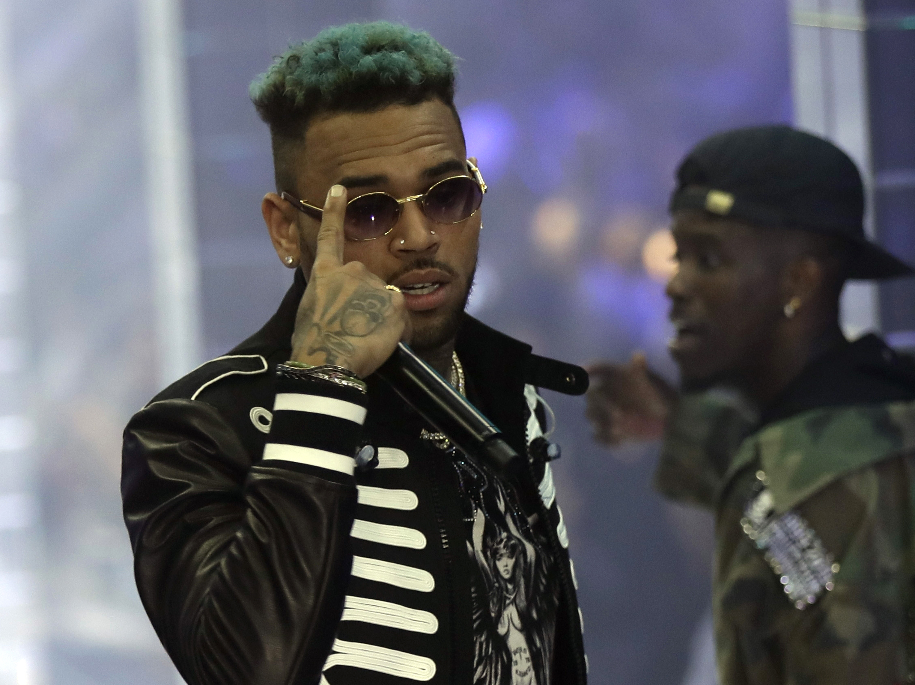 caption: Chris Brown performs during Fashion Week last fall in Milan, Italy. The Paris prosecutor says the singer and two other individuals were arrested. Brown has been accused of rape and narcotics possession.