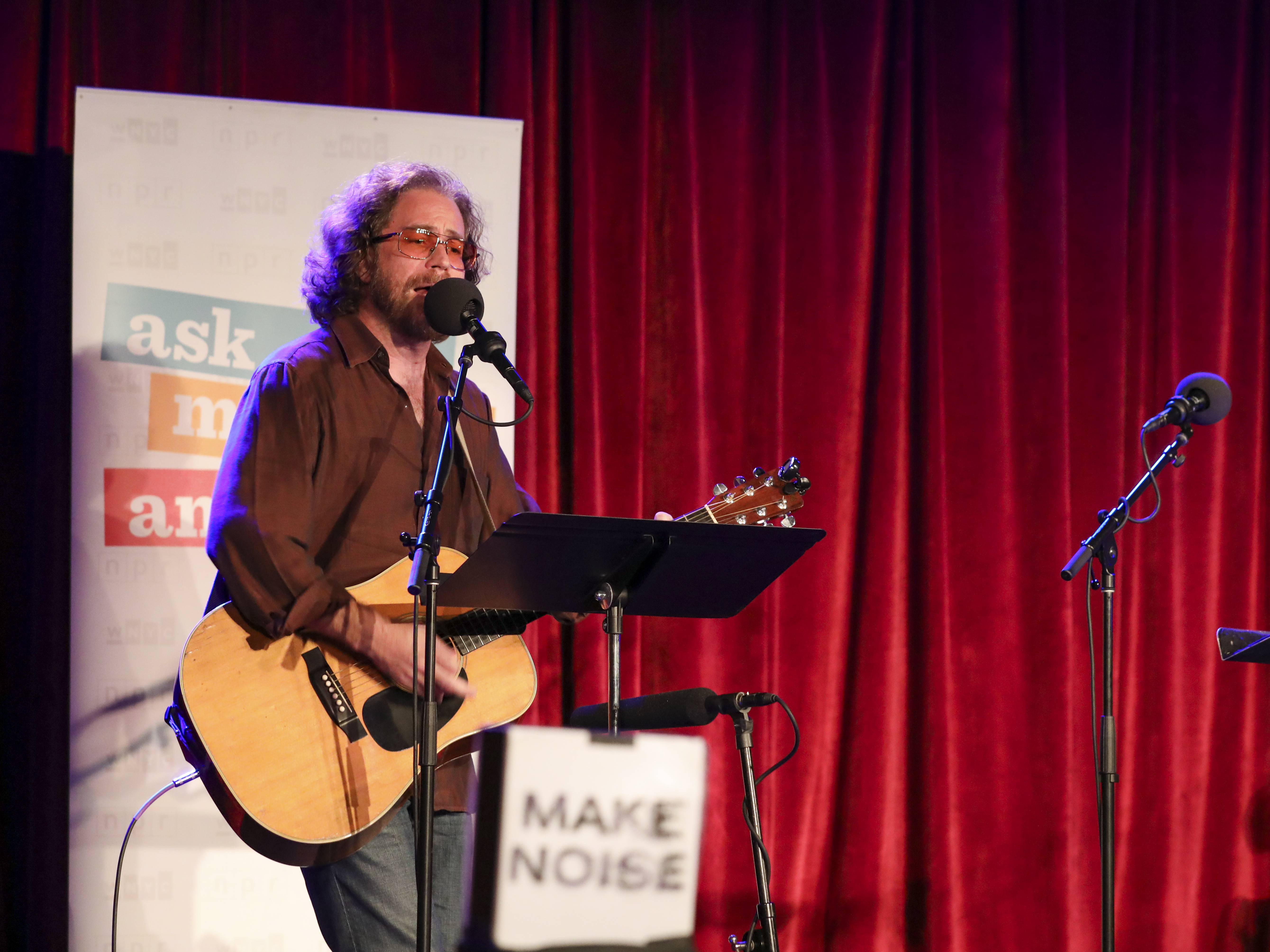 caption: Ask Me Another's house musician Jonathan Coulton leads a music parody game at the Bell House in Brooklyn, New York.