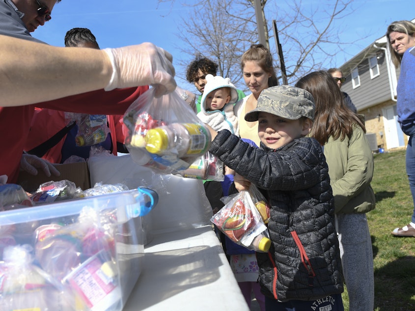 caption: Kids whose schools are shut down in Anne Arundel County, Md., receive food in Annapolis on Monday, as part of a program to ease the burden of feeding students while schools are closed for two weeks due to the coronavirus.
