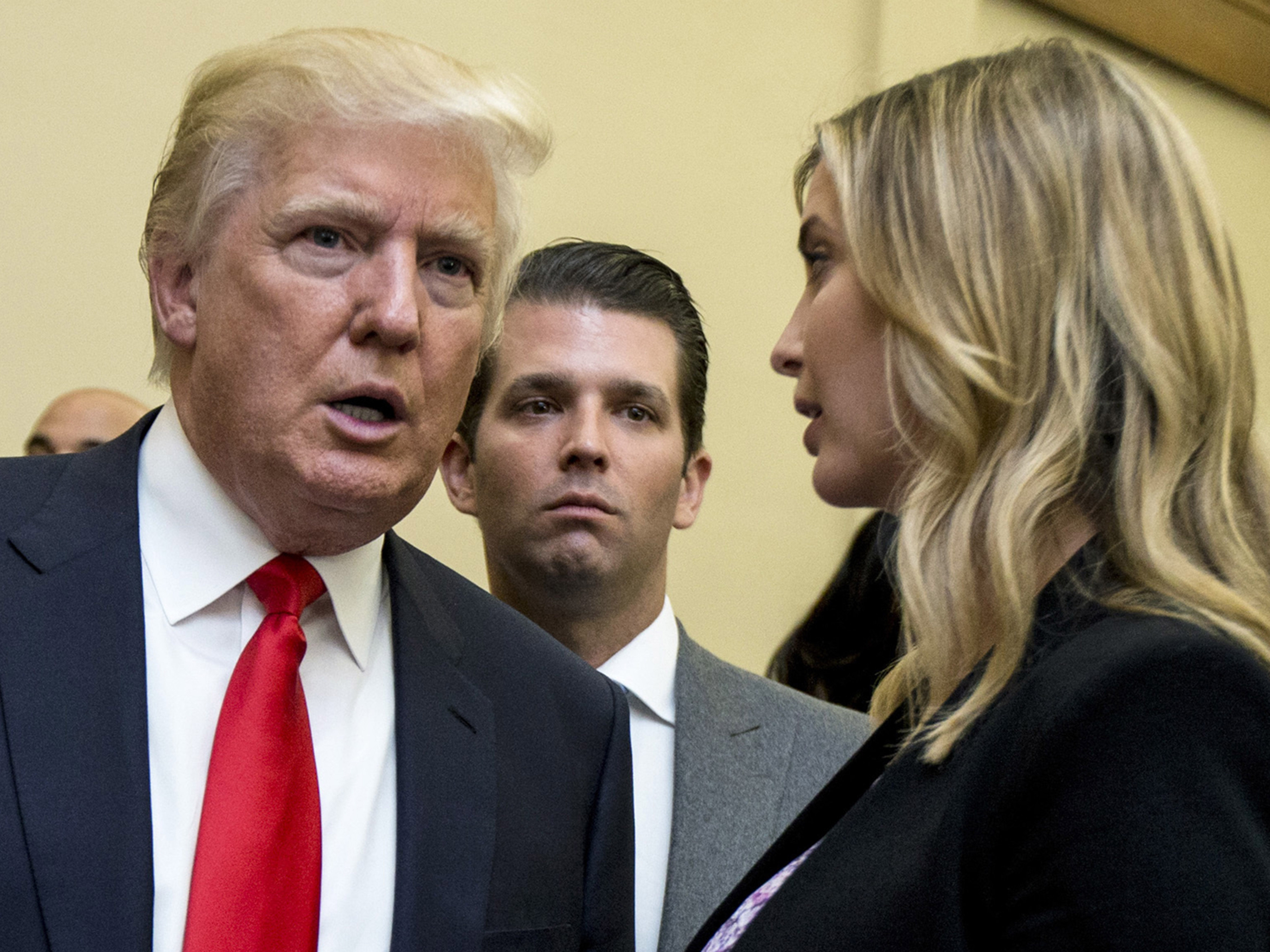 caption: Donald Trump, left, his son Donald Trump Jr., center, and his daughter Ivanka Trump speak during the unveiling of the design for the Trump International Hotel in Washington, on Sept. 10, 2013.
