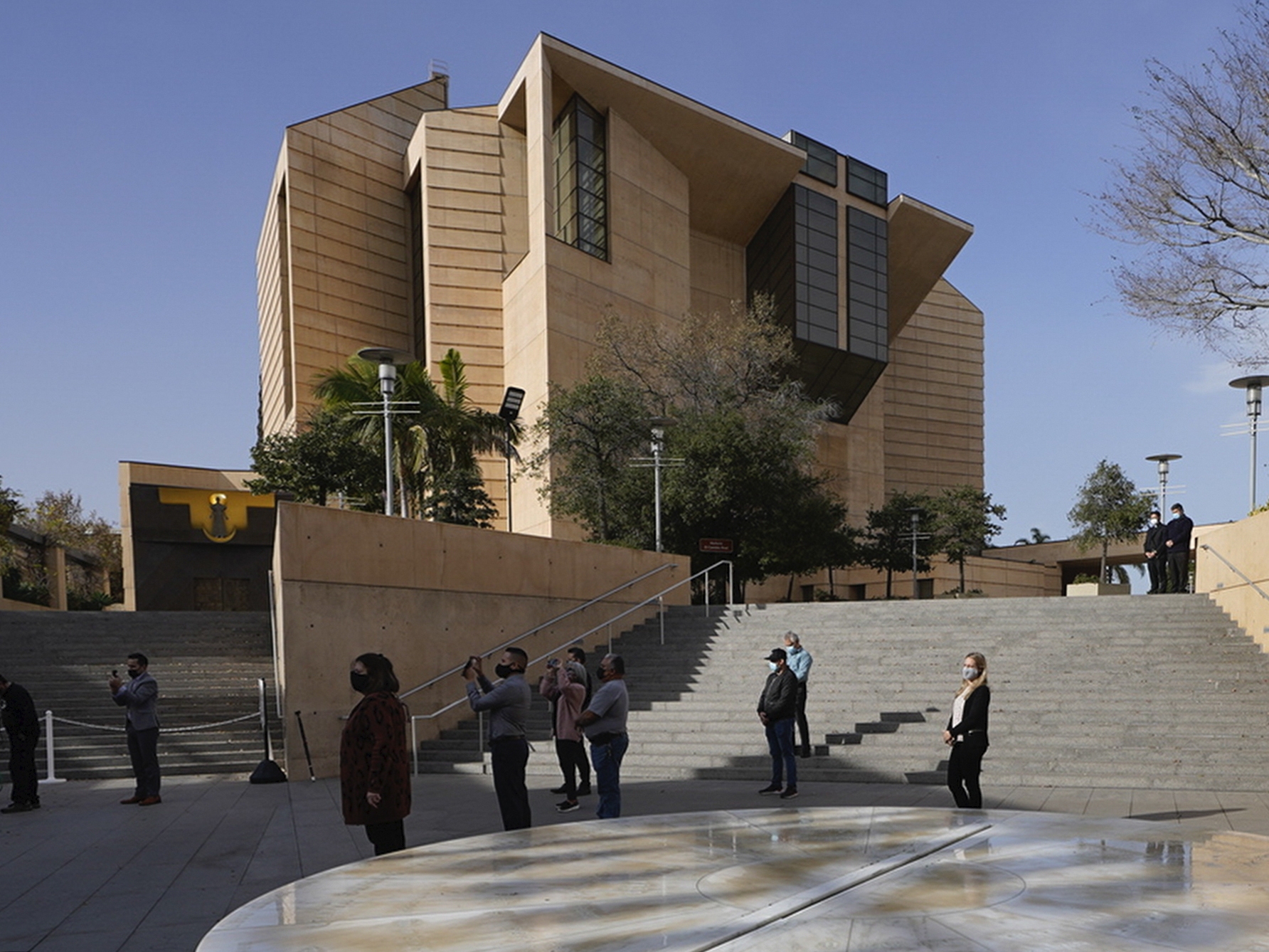caption: People attend a memorial service outside the Cathedral of Our Lady of Angels in Los Angeles, on Jan. 19, 2021.