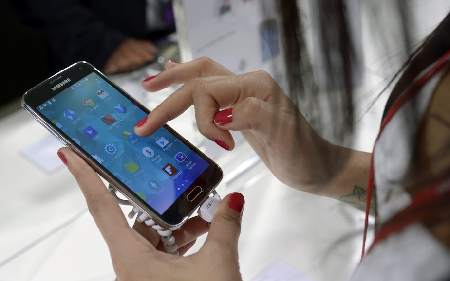 caption: A Samsung Galaxy S5 is demonstrated at the Mobile World Congress, the world's largest mobile phone trade show in Barcelona, Spain.